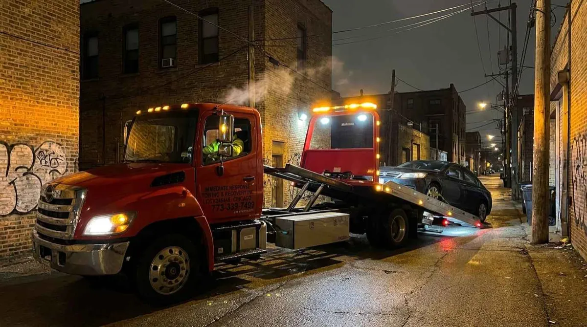 Immediate Response Towing Chicago flatbed tow truck loading a disabled vehicle at night