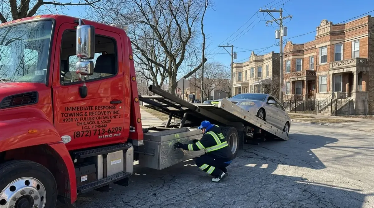 Flatbed truck loading disabled car in Humboldt Park