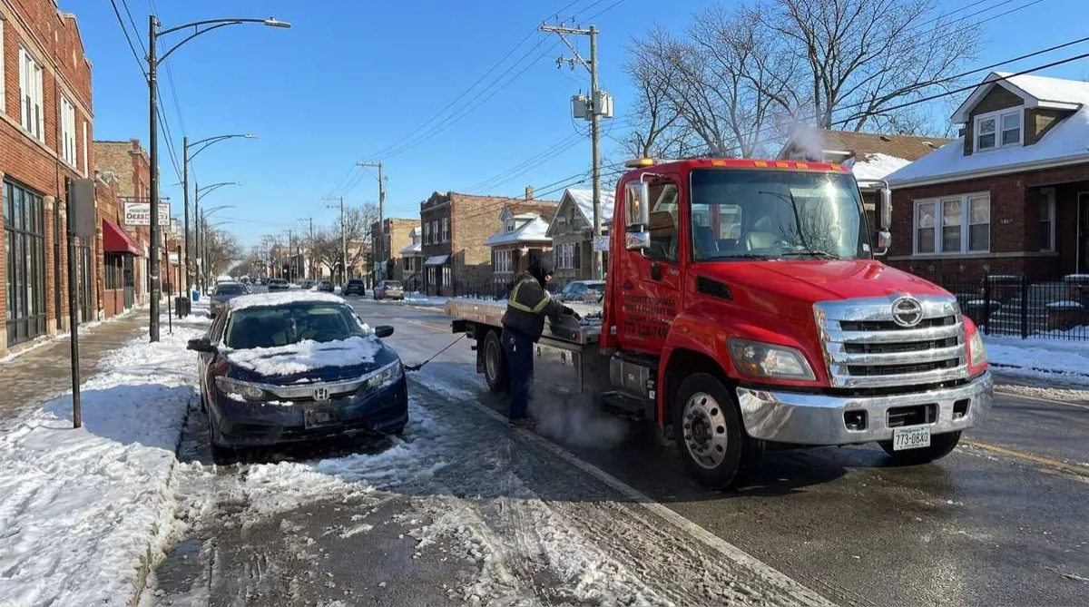 Tow truck assisting a stalled car on Fullerton Avenue on Chicago's Northwest Side