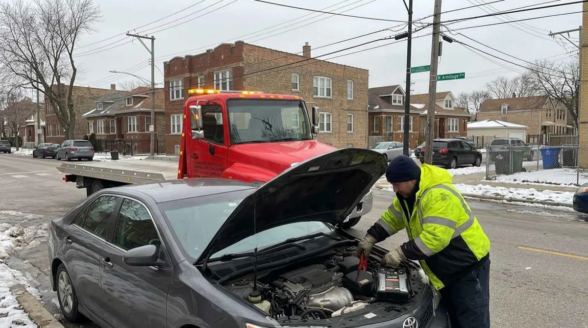 Technician giving a battery jump start to a car in Hermosa, Chicago