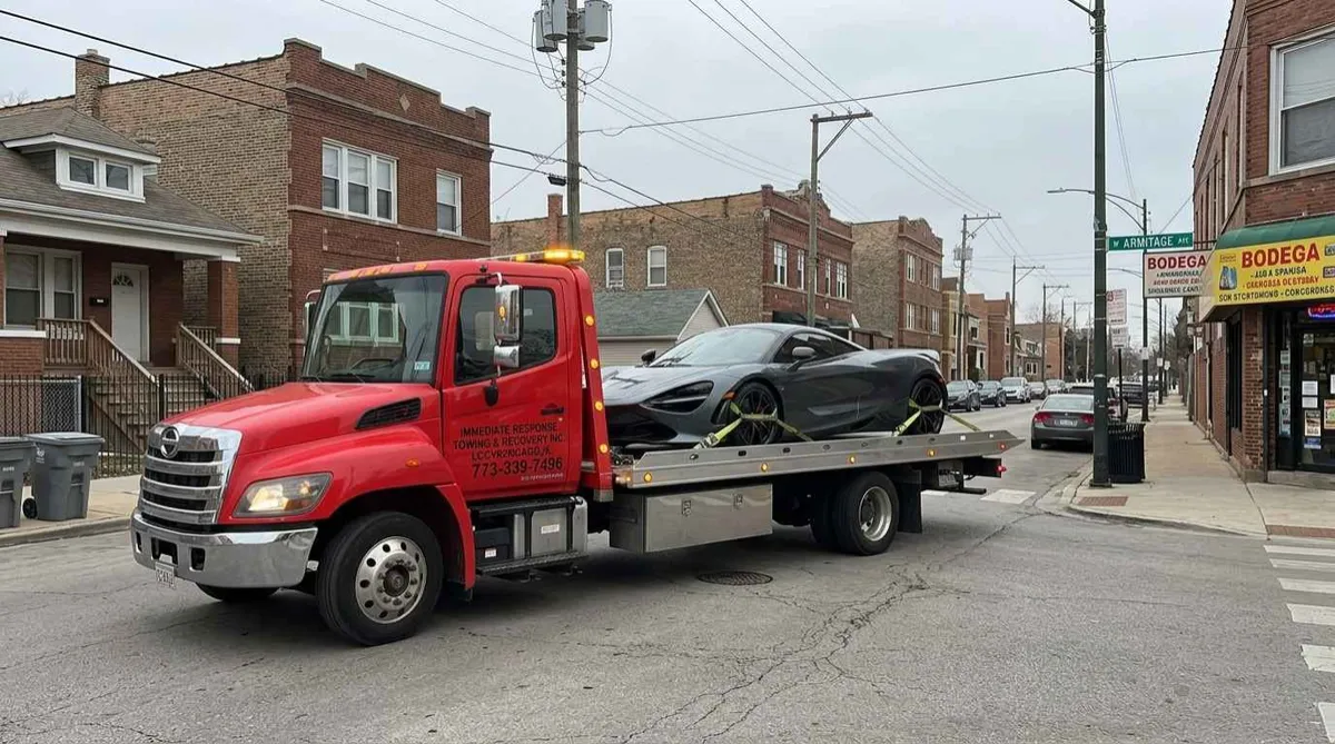 Flatbed tow truck transporting a disabled exotic car in Hermosa, Chicago