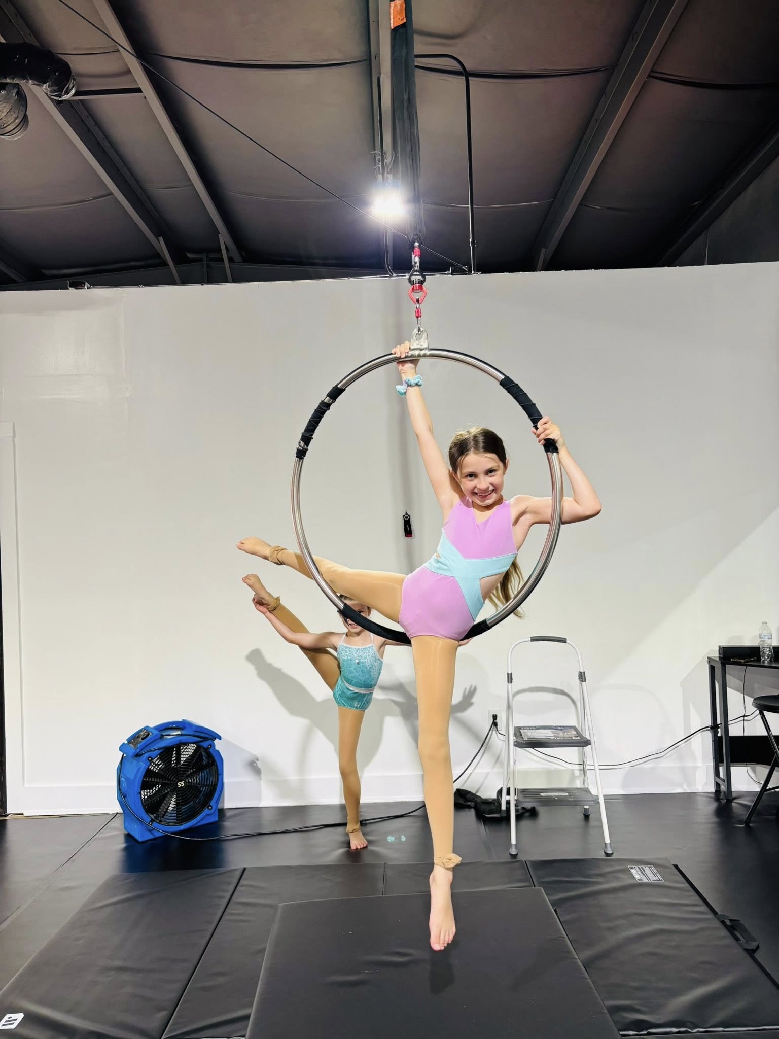 Dance instructor encouraging young dancer in studio