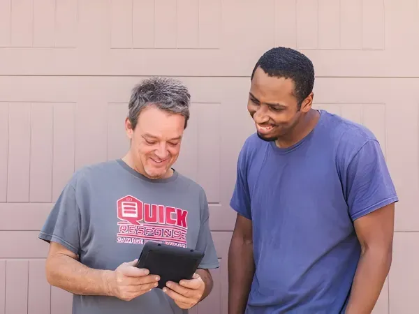 Smiling homeowner on the phone contacting a garage flooring company to request a free estimate.