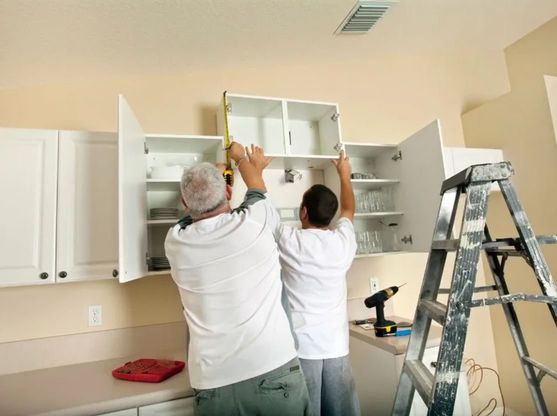 technicians installing a garage cabinet