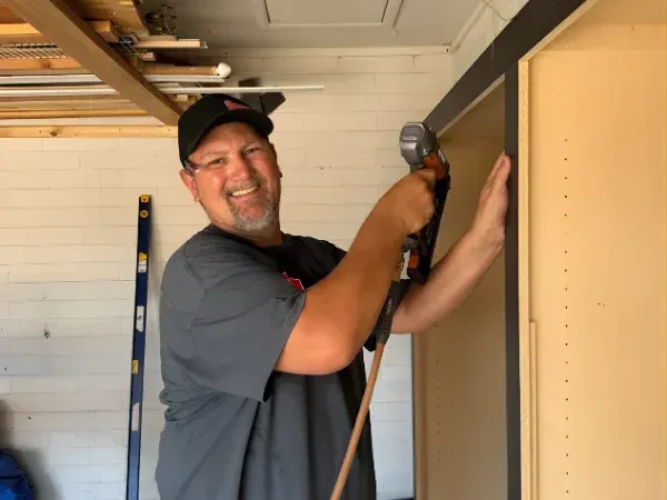 Garage cabinet installer working on custom cabinet installation inside a residential garage
