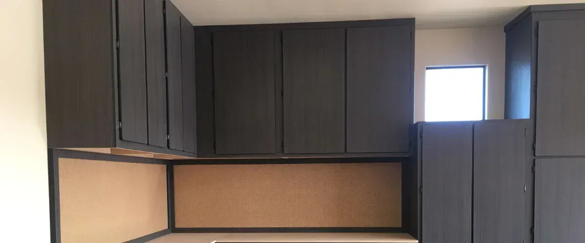 Custom garage cabinet system with workbench, pegboard wall, and multiple storage drawers