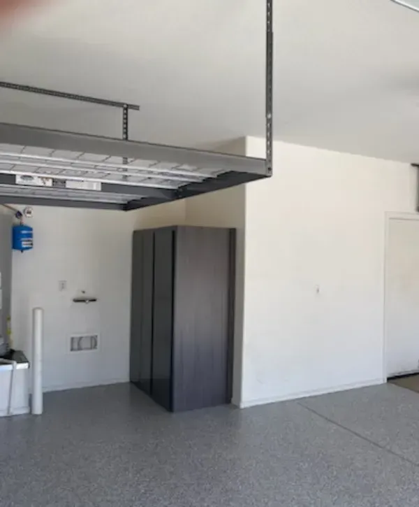 ModernDark garage cabinet placed under ceiling-mounted loft shelf garage cabinet with white flat panels and black hinges