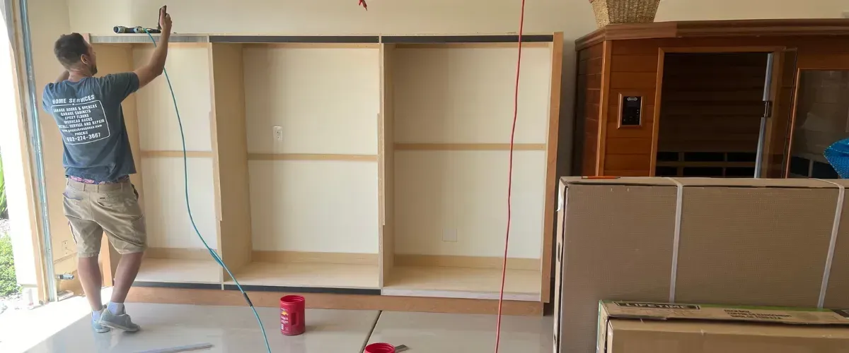 Garage cabinet installation in progress with worker and tools
