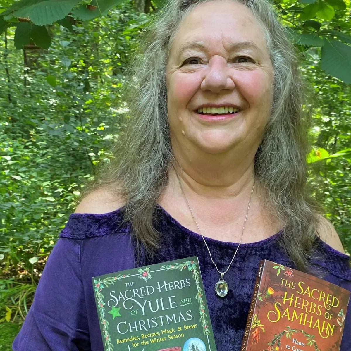 Ellen Evert Hopman with two of her books, The Sacred Herbs of Samhanin and The Sacred Herbs of Yule and Christmas