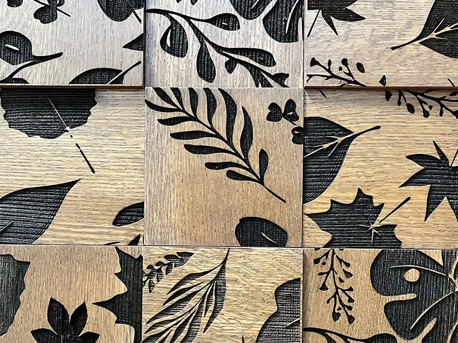 The image shows a custom 3D block wall with floral laser etching
