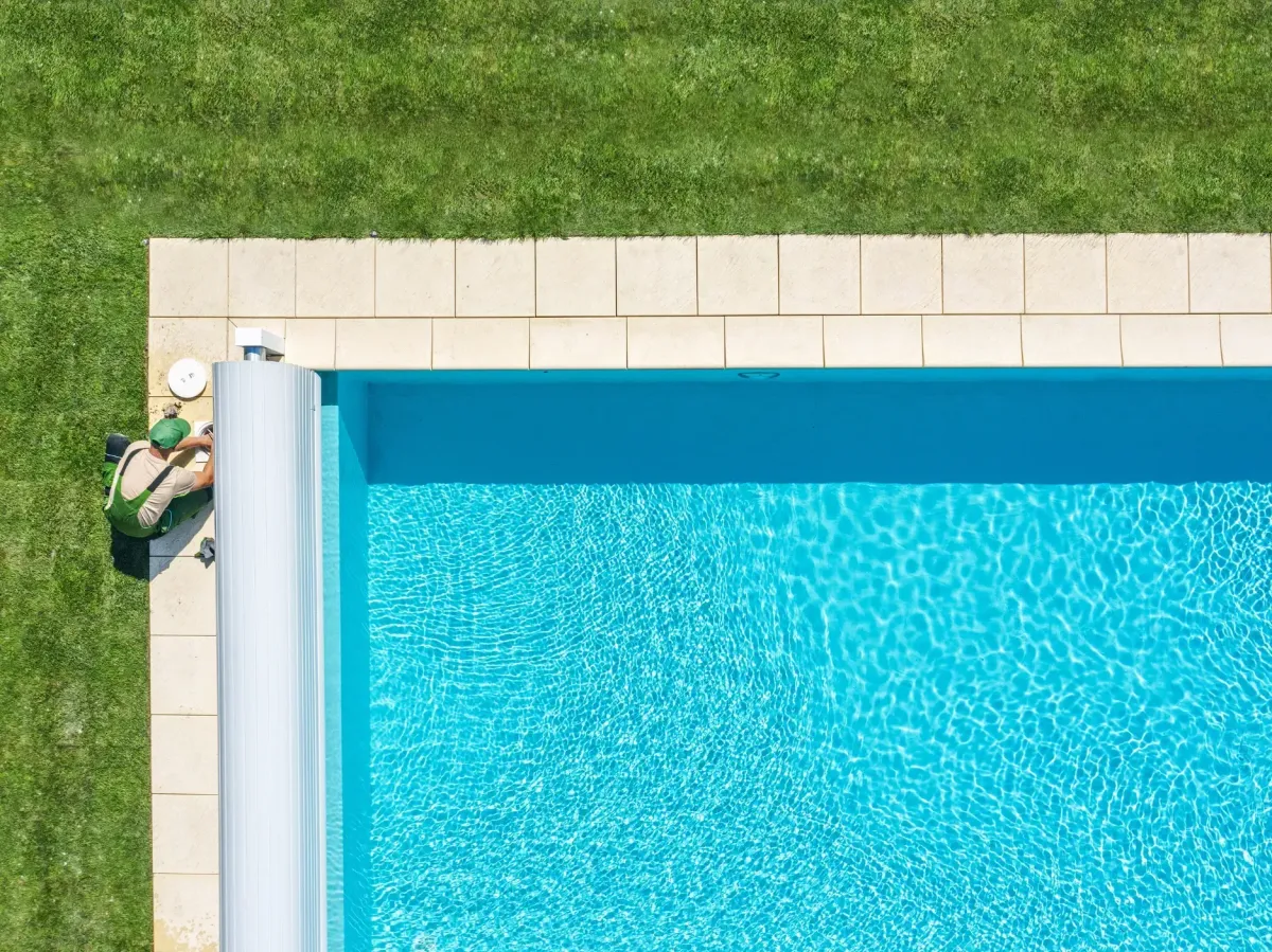Pool cleaning professional working on a pool cover