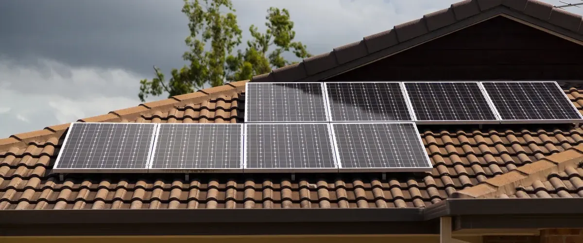 Row of solar panels on a residential roof in Foothills Village AZ after professional cleaning.anels installed on a red metal roof of a modern house.