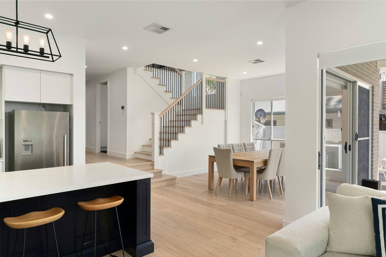 Bright open-concept kitchen, dining, and living area in a newly completed home ready for a final walkthrough