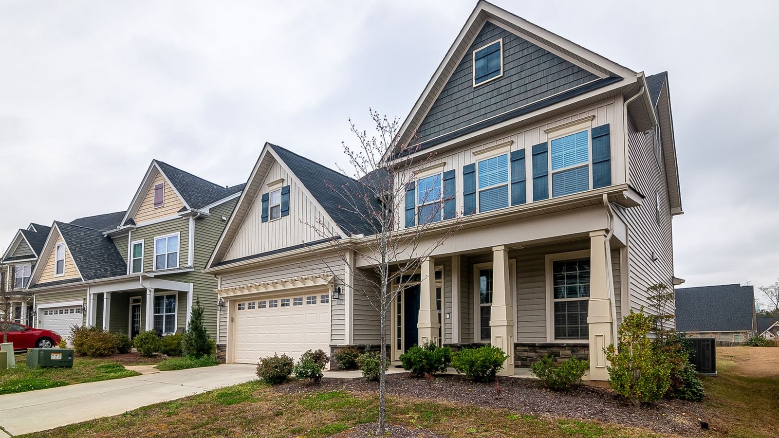 A row of newly built single-family homes with garages and driveways in a residential neighborhood