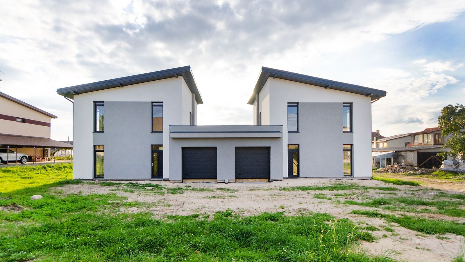 Two newly built single-family homes side by side on a cleared lot