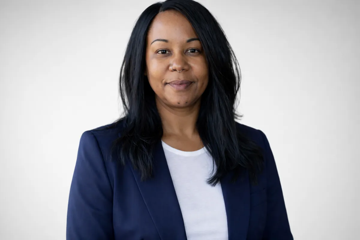 A modern, clean 3:2 image showing a diverse family of four—parents and two children—gathered around a kitchen table, smiling as they review financial documents together. The background is bright and airy, with soft natural light and minimalistic decor, conveying trust and optimism.