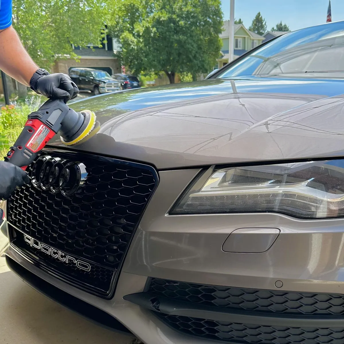 a blue sports car parked next to a lake