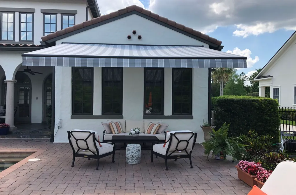 Retractable awning extended over patio, providing shade and UV protection for outdoor seating area