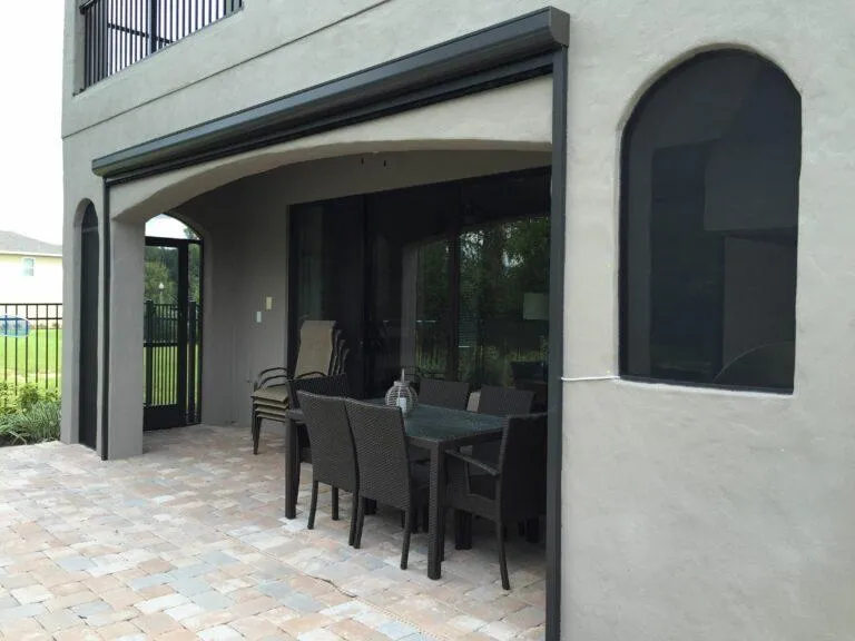 Housed retractable screen unit installed on a residential exterior blending into the exterior architecture