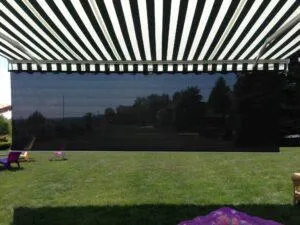 Large retractable awning casting wide shade over patio furniture
