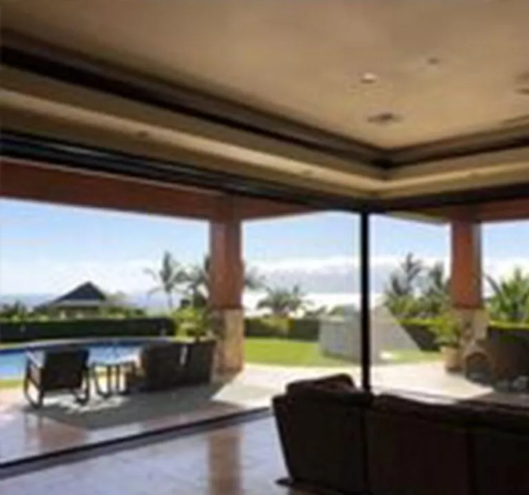 Corner-mounted manual screen enclosing angled patio section