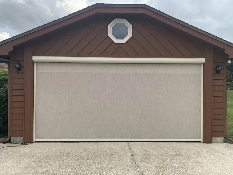 Garage opening with solar screen providing shade and visibility on a sunny Florida afternoon