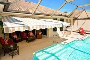 Awning mid-extension over backyard paver area during the day