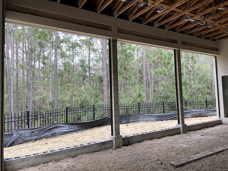Technician installing recessed tracks and mounting brackets for seamless screen integration at the client's residence