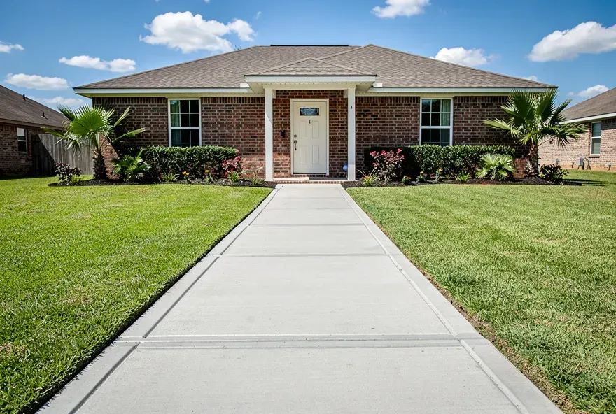 Finished concrete sidewalk running alongside a home
