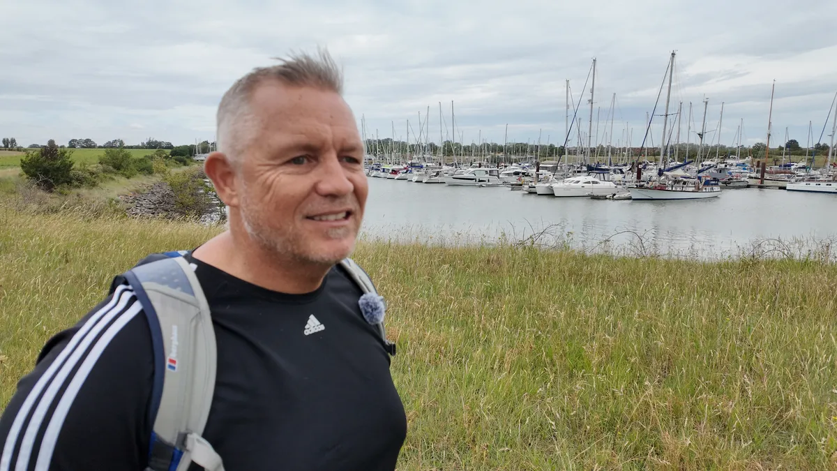 Wayne Phipps standing outdoors beside a river.