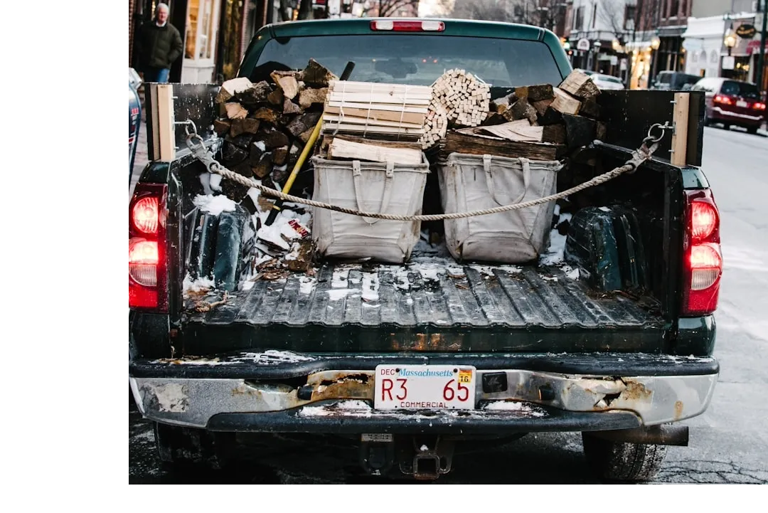pickup truck loaded by firewood while parked on concrete roadway
