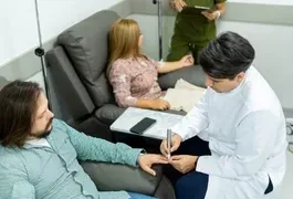 A doctor in a medical setting is taking a blood sample from a patient. The scene includes various healthcare equipment, and the environment appears comfortable. The doctor is focused on the task, while the patient looks calm.