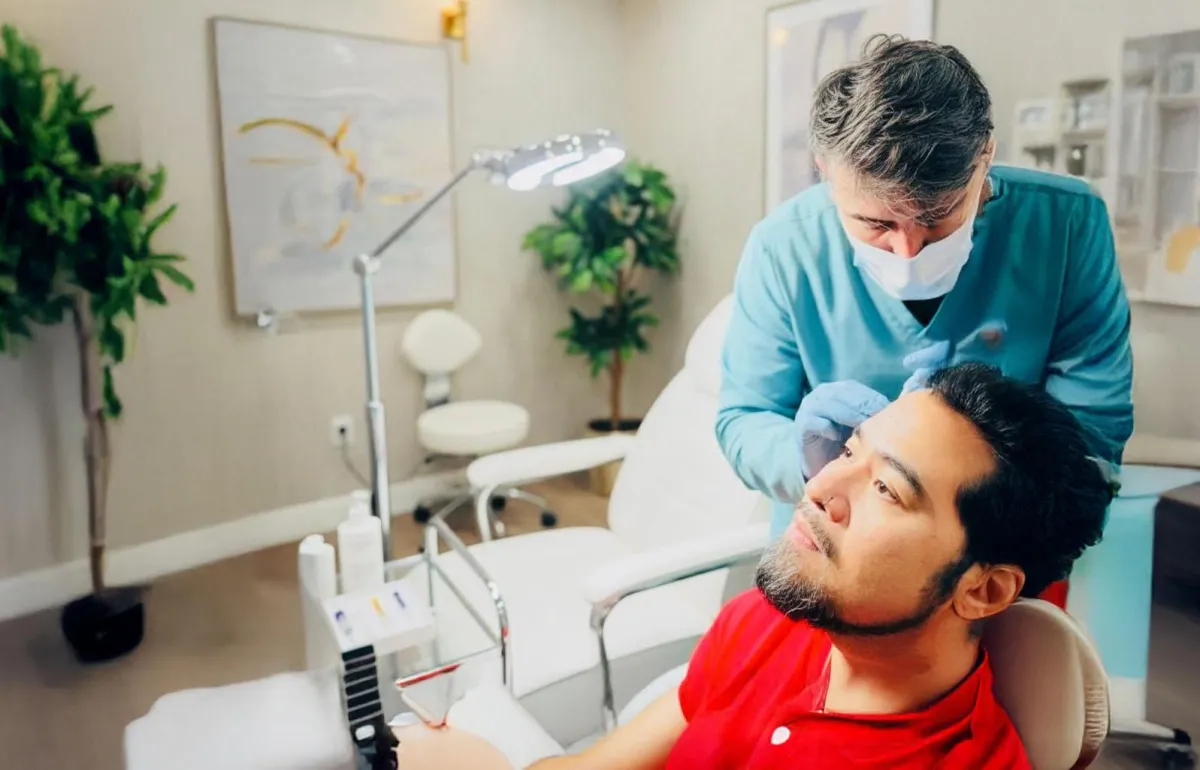 A group of people surrounding a child lying on a bed, in an indoor setting that includes medical equipment.