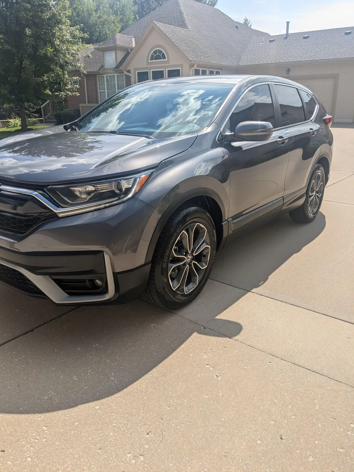 Technician in a professional auto detailing shop polishing a sedan.