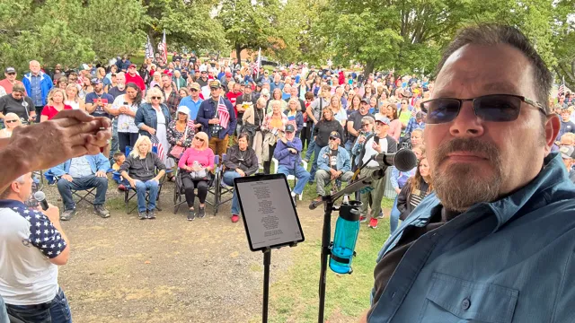 person reaching black heart cutout paper