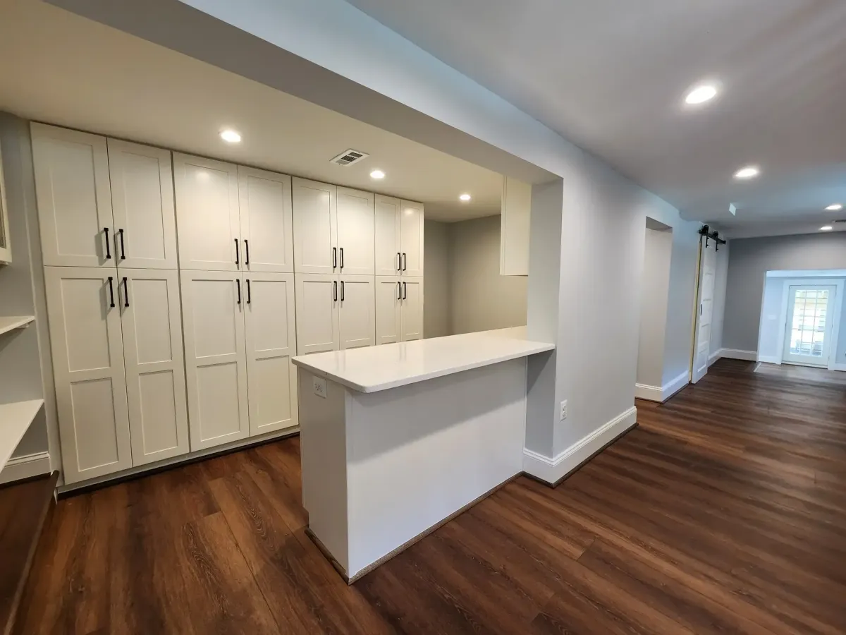 Finished Arlington basement recreation room with LVP flooring, custom cabinetry, and storage countertop