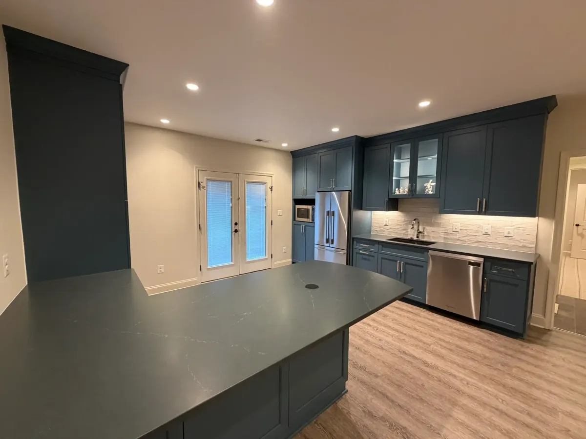 Falls Church basement remodel with custom cabinetry in wet bar and TV lounge areas, LVP flooring throughout