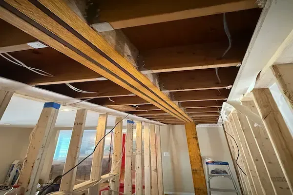 Reston Virginia flitch beam installation during load-bearing wall removal showing steel plate and LVL sandwich construction