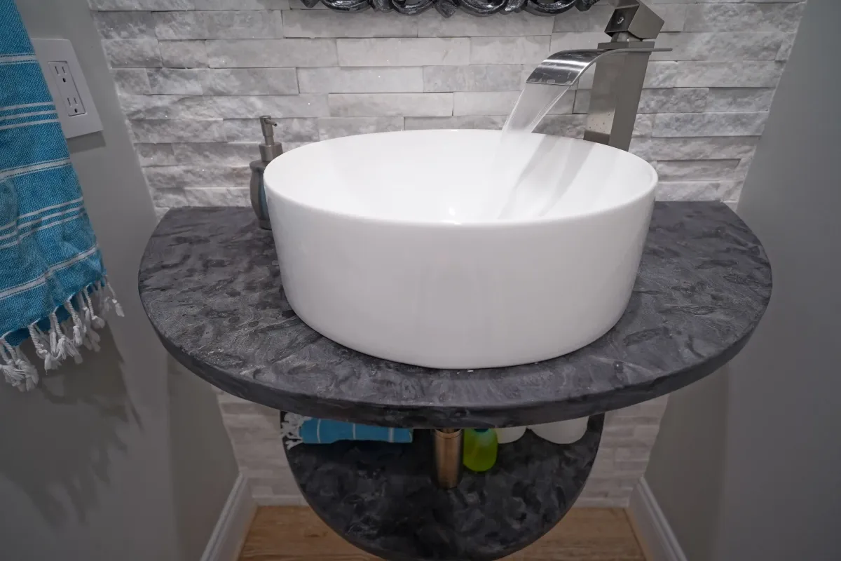 Oakton Virginia powder room remodel with floating European sink stone tile accent wall and modern fixtures