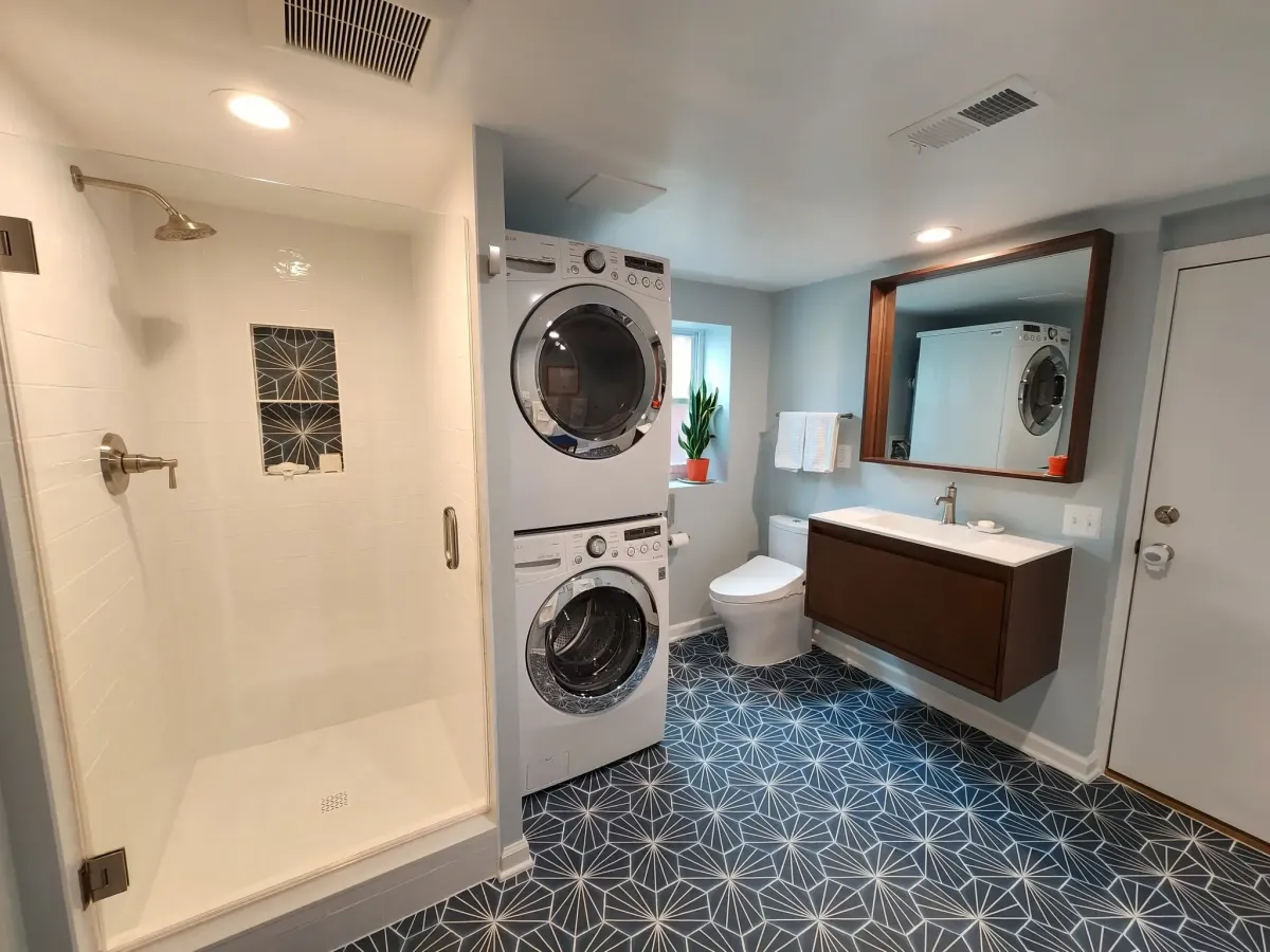 Falls Church Virginia completed basement bathroom with shower stacking washer dryer sink toilet and geometric pattern tile floor