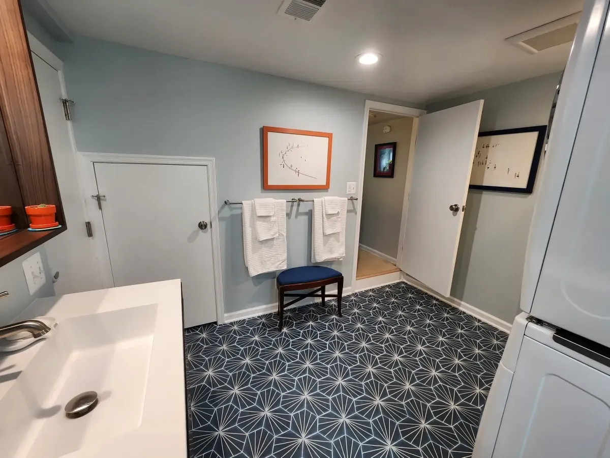 Falls Church Virginia basement bathroom entry with geometric pattern tile floor and new bathroom New plumbing, electrical and HVAC including concrete cutting