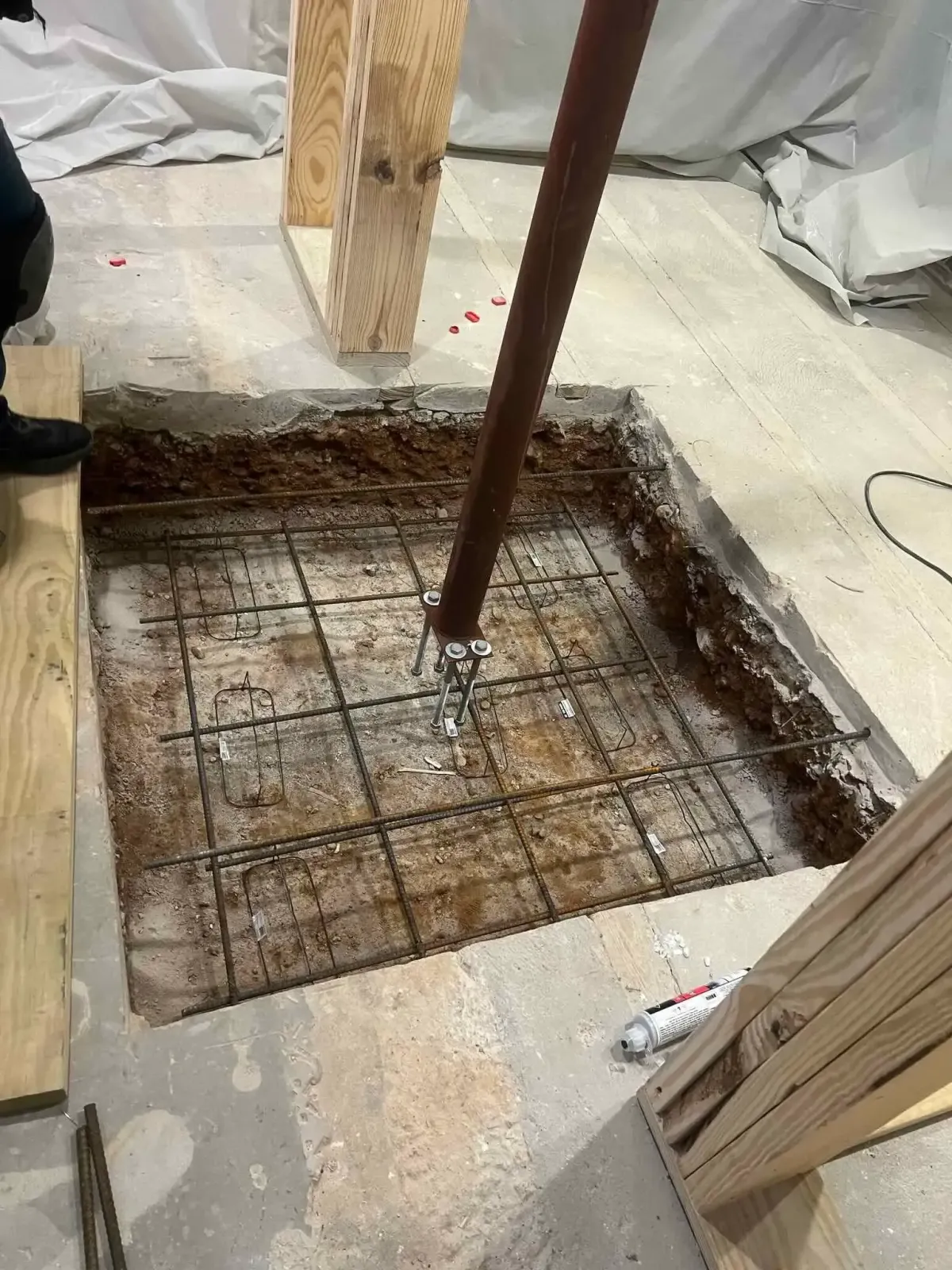 Damaged Arlington basement before remodel showing inadequate deck post supporting steel beam