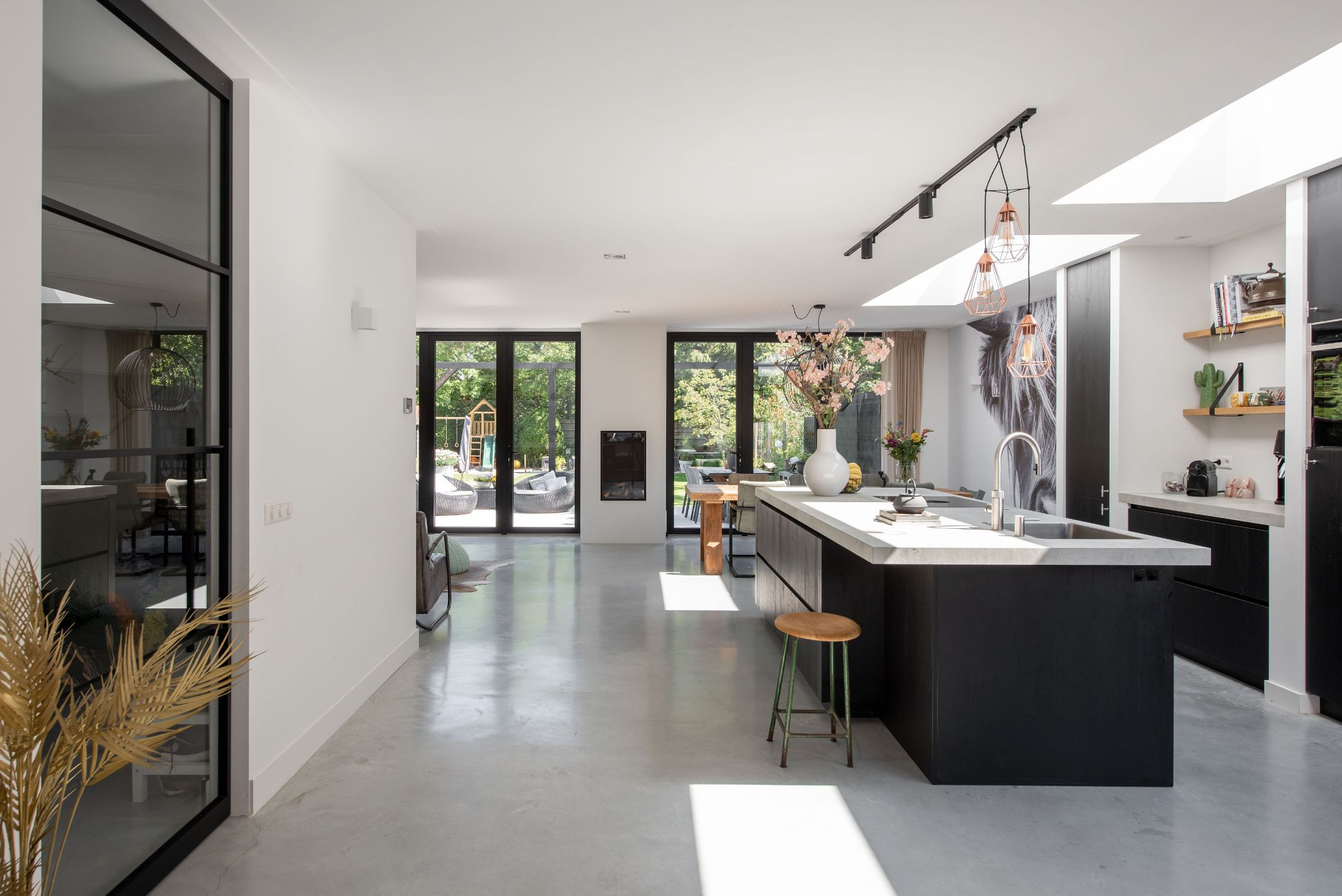 Volledig gerenoveerde open keuken met kookeiland en woonkamer door LevelUp Renovaties