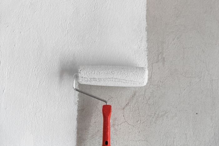 Schilder brengt verf aan op een muur met verfroller tijdens schilderwerken door LevelUp Renovaties