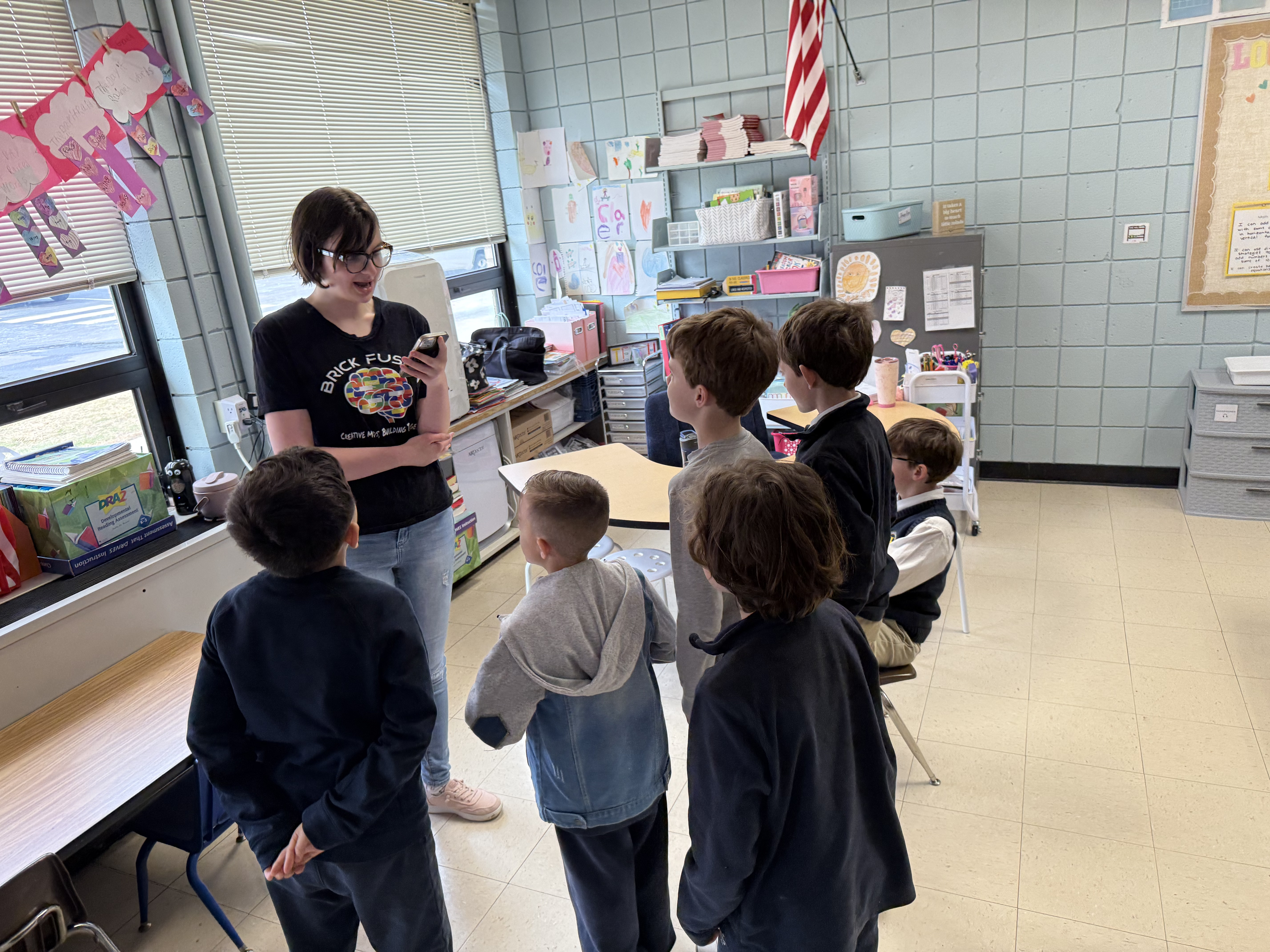 Action shot of an instructor helping a group of kids build a towering LEGO structure, high-saturation