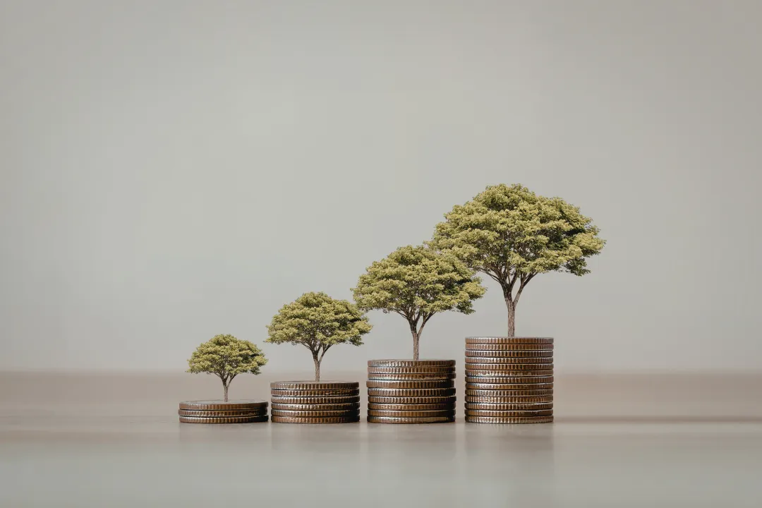 A small house bank with a coin and blank card.