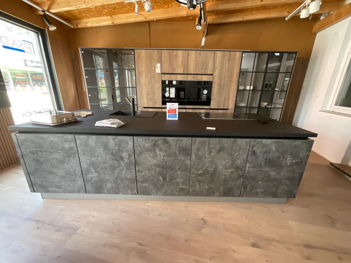 Moderne Küche mit dunklen Fronten und Holzbalken