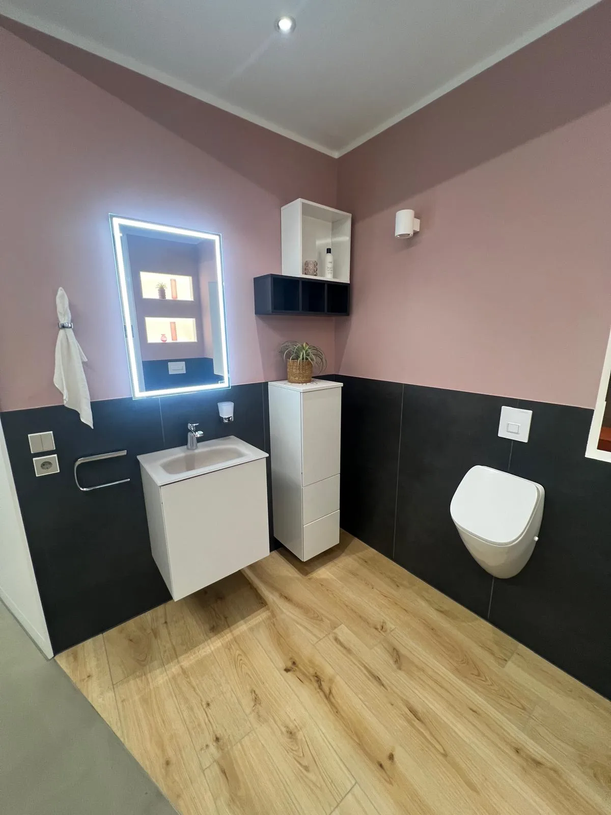 Modernes Badezimmer mit Holzoptik und dunklen Flächen