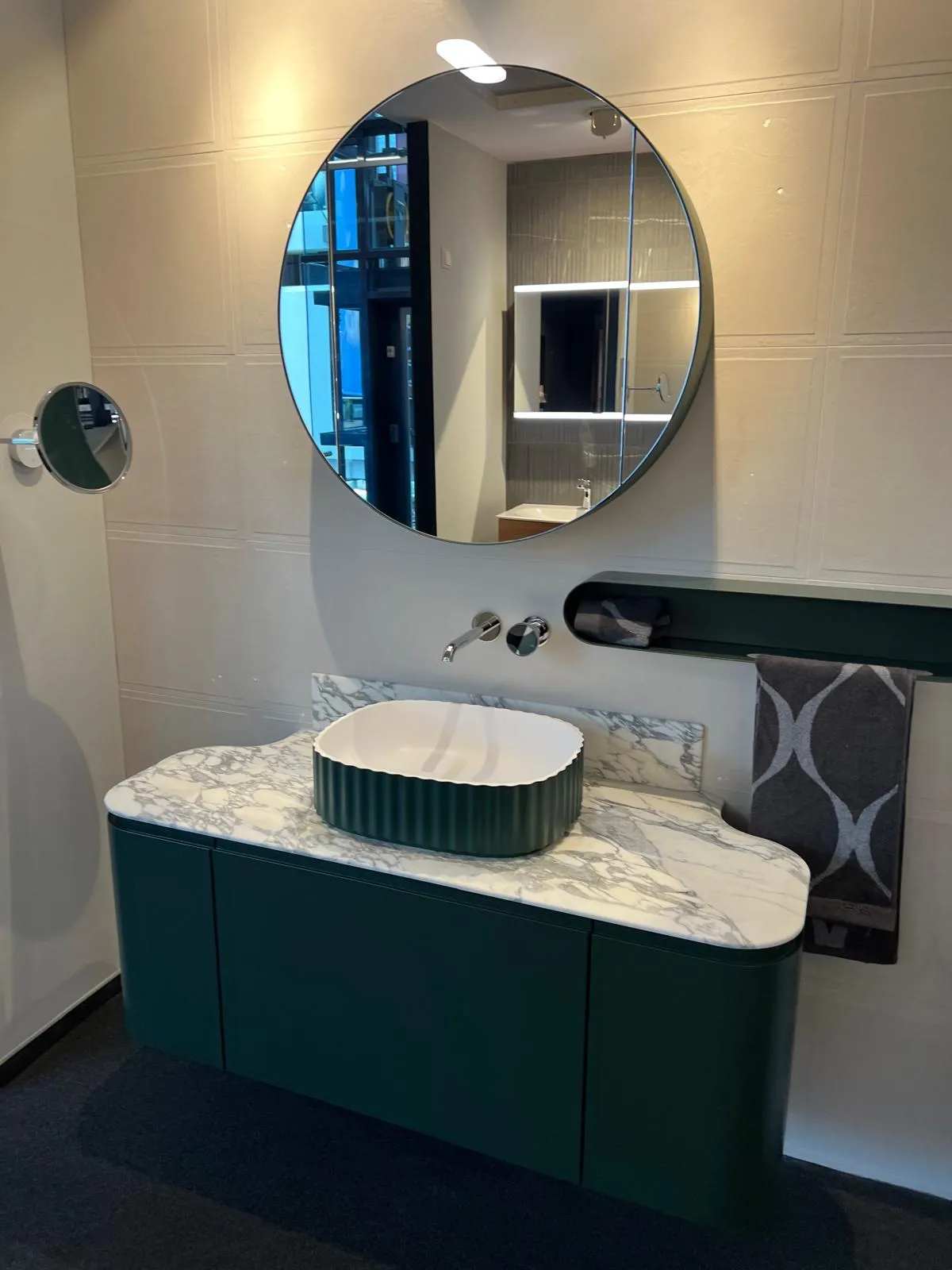 Modernes Badezimmer mit rundem Spiegel und Waschtisch