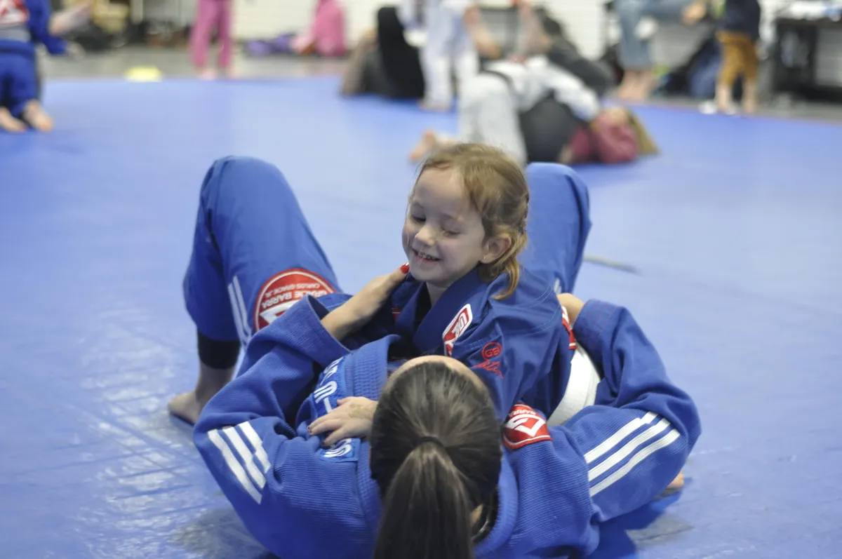 A nude dancer performs a complex movement on the floor.